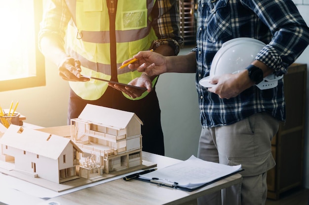 Construction engineer working at blueprint to build large commercial buildings in office Engineering tools and construction concept