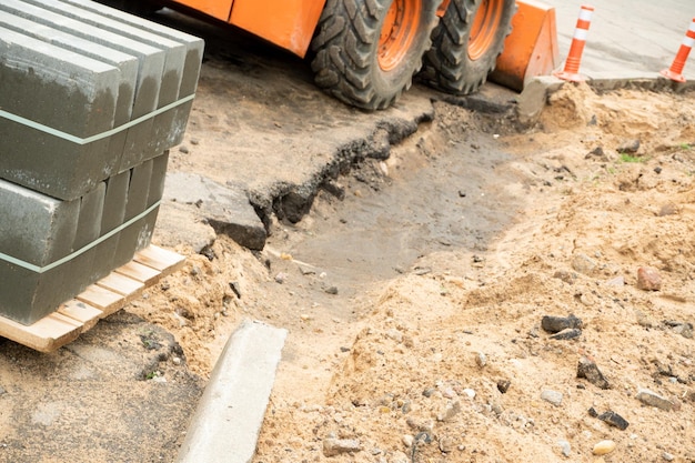 Construction of a footpath Laying granite tiles on sandy ground and replacing sewer hatches