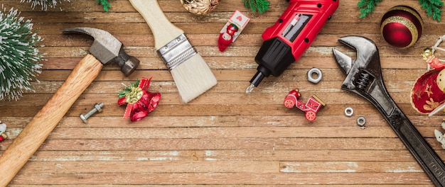 Construction handy tools with Christmas ornament on wood