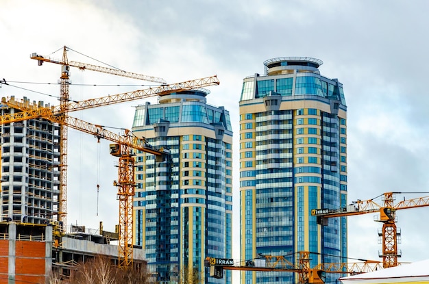 Construction of high-rise buildings with cranes.