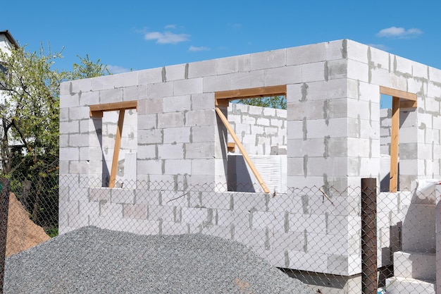 Construction of a house from gas silicate white blocks A mountain of gravel near an unworthy house