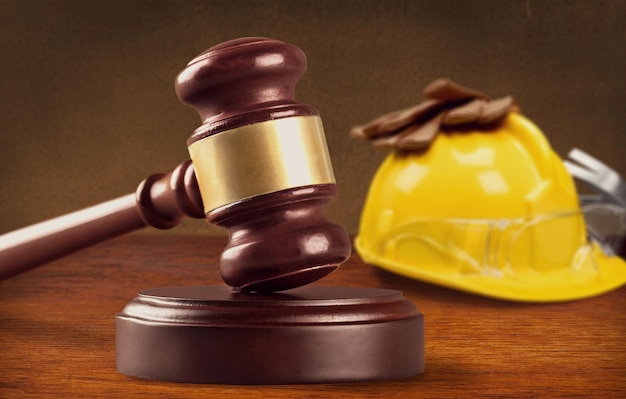 Construction and labor law concept. Judges gavel with yellow hard hat,