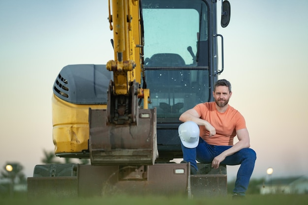 Construction man industry with excavator at industrial site Worker in helmet build with bulldozer