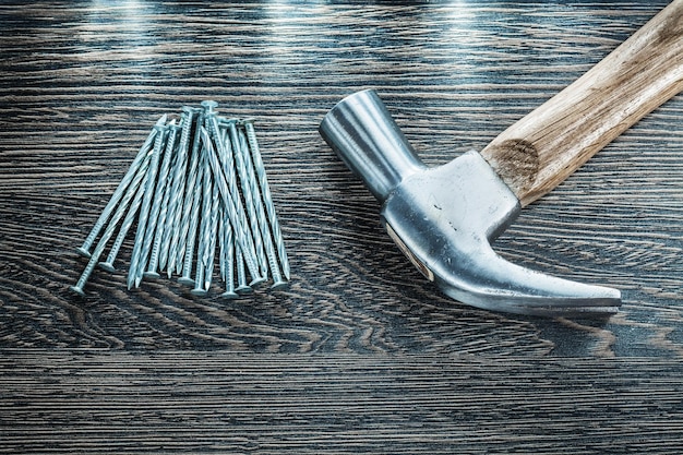 Construction nails claw hammer on wooden board