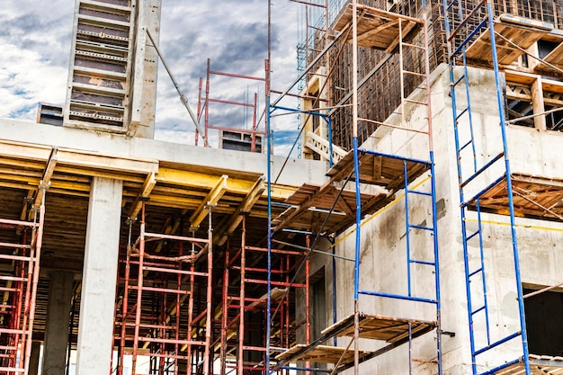 Construction of a new monolithic reinforced concrete house Scaffolding on the facade of a building under construction Working at height on a construction site