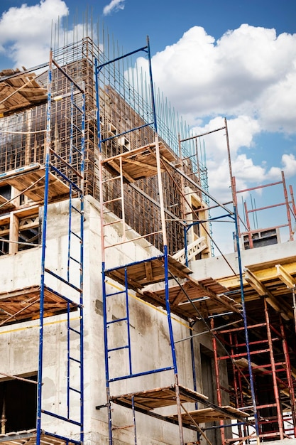 Construction of a new monolithic reinforced concrete house Scaffolding on the facade of a building under construction Working at height on a construction site