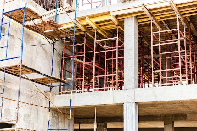 Construction of a new monolithic reinforced concrete house Scaffolding on the facade of a building under construction Working at height on a construction site