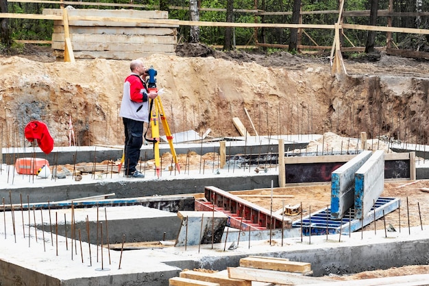 Construction of a residential area Geodetic stakeout Surveyor at a large construction site A man with a tachometer during work Makshader