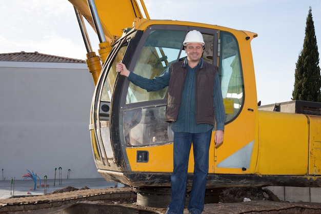 Construction safety concept, close-up worker holding helmet with crane in the background