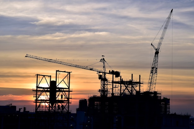 Construction site .Silhouette tower cranes build large residential buildings  at construction site .