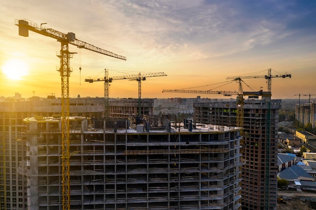 Construction site with cranes at sunset Construction of an apartment building