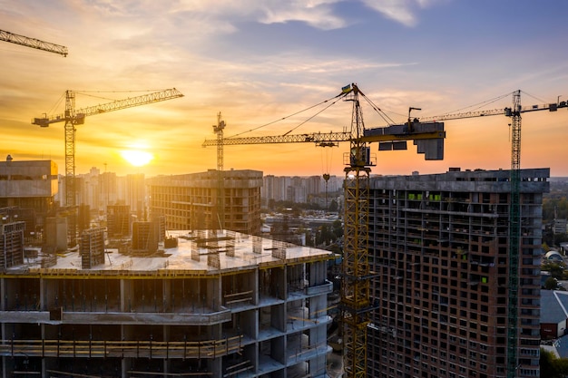 Construction site with cranes at sunset Construction of an apartment building