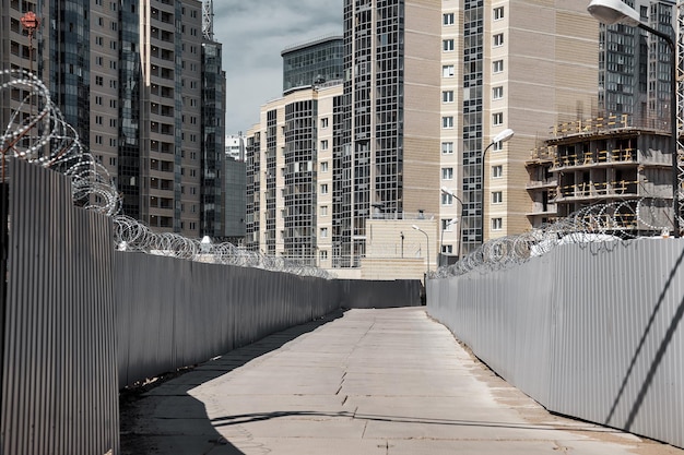 Construction site with fencing and concrete road against background