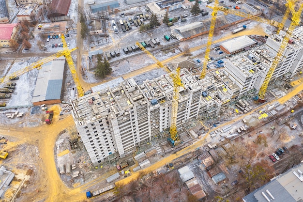 A construction site with yellow tower construction cranes is a concept. housing construction.