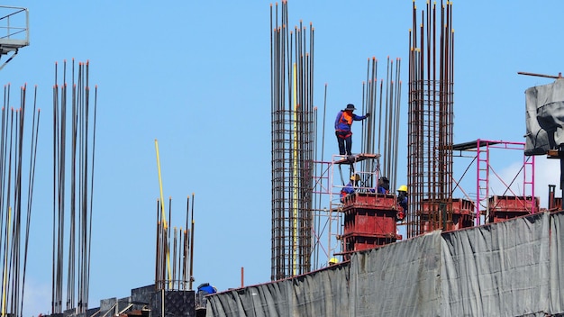 Construction site and worker that working on high building and concrete steel material.