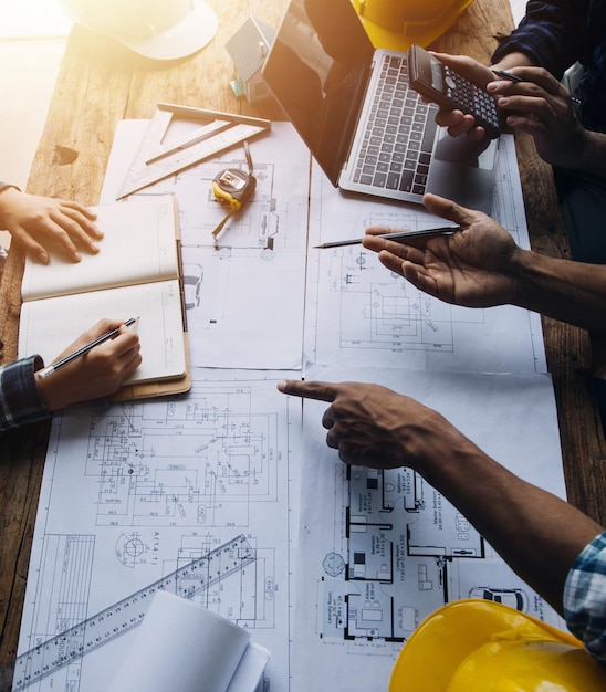 Construction and structure concept of engineer working drawing on blueprint meeting for project working with partner on model building and engineering tools in working site construction concept