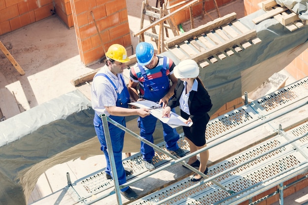 Construction worker and architect discussing plans on building site