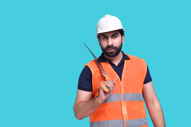 construction worker carring handsaw on his shoulder and looking front indian pakistani model