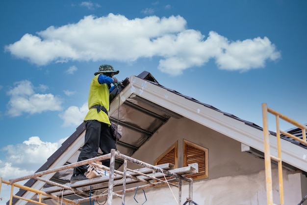 Construction worker install new ceramic tile roof