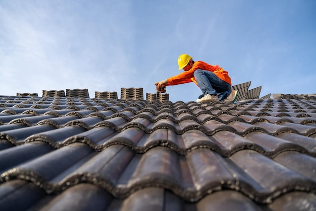 A Construction worker install new roof Electric drill used on new roofs with Concrete Roof Tiles Roofing tools