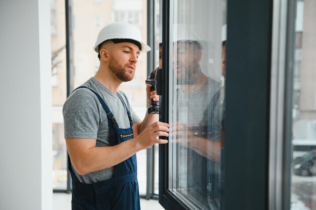 Construction worker installing window in house