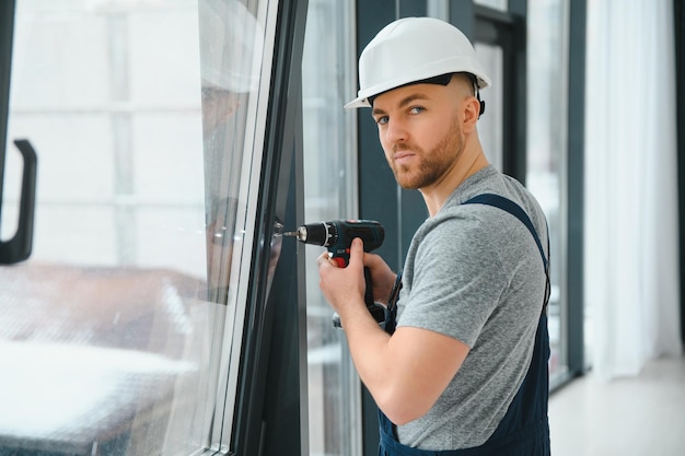 Construction worker installing window in house