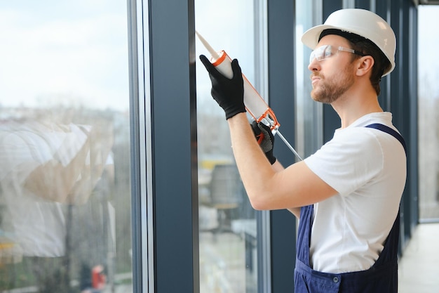 Construction worker installing window in house