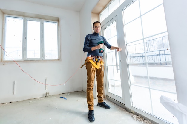 Construction worker installing window in house