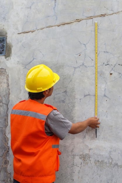 Construction worker or male builders use tape measures to measure and calculate construction site