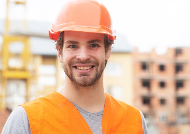 Construction worker man in work clothes and a construction helmet portrait of positive male builder