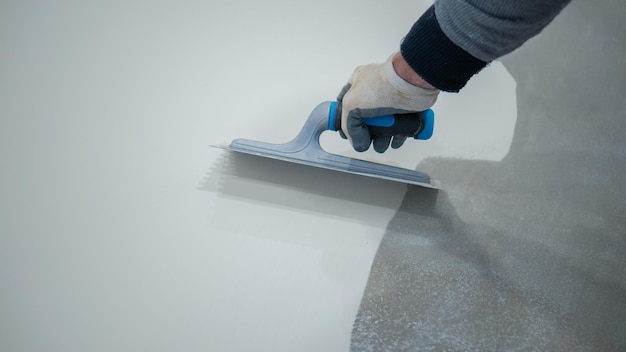 Photo a construction worker renovates the balcony floor and spreads waterproof polyurethane resin and glue