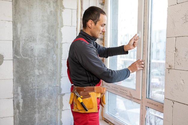 Construction worker repairing windows in house.