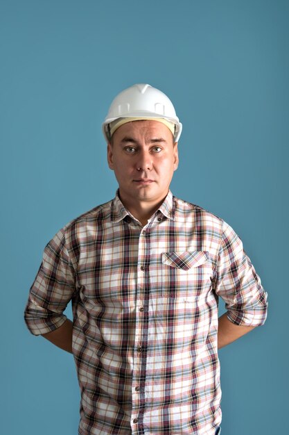 A construction worker in a shirt and a white helmet on a blue background