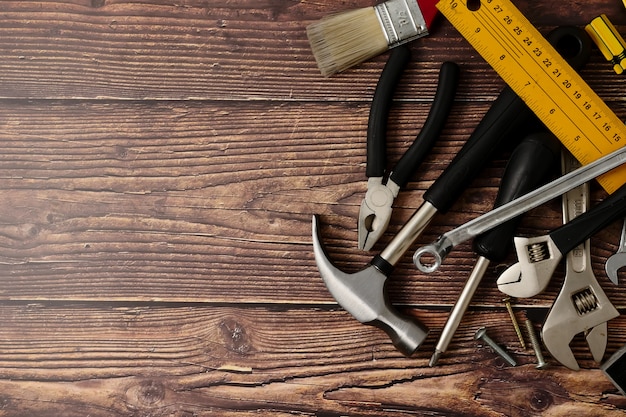 Construction worker tools on wooden table background.