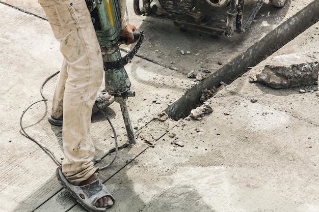 Construction worker using jackhammer drilling concrete surface