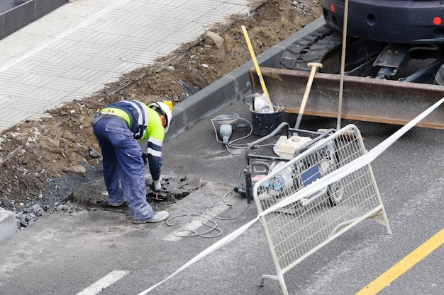 Construction worker with several machines working on the renovation of a city street