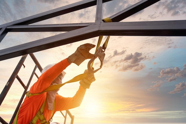 A Construction workers are working on steel roof trusses with Fall arrestor device for worker with hooks for safety body harness on the construction site