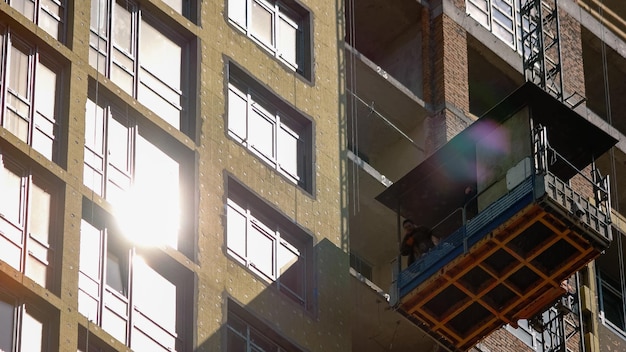 Constructruction workers on the elevator are moving down high speed motion