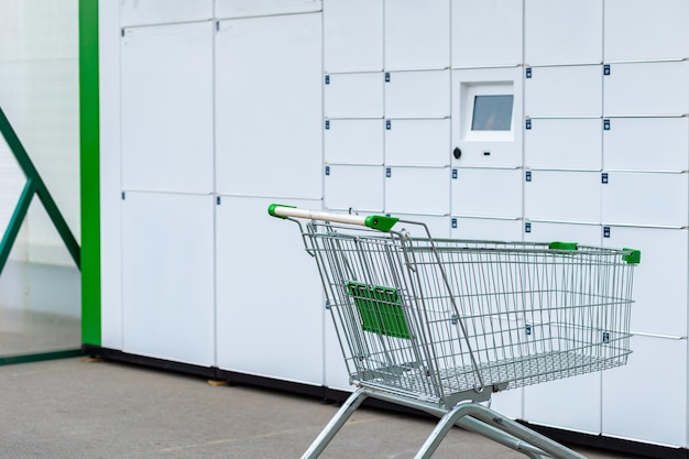 Consumer basket on wheels for shopping against the background of mailboxes