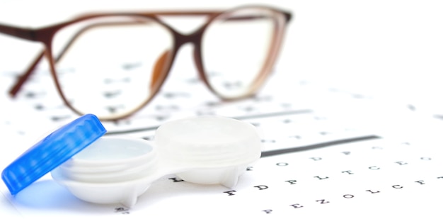 Contact lenses case and eye glasses on and eye test chart