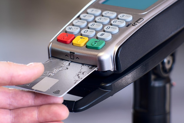 Photo contactless payment concept female customer holding credit card near nfc technology on counter client make transaction pay bill on terminal rfid cashier machine in restaurant store close up view