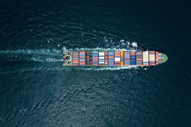 Container cargo ship sailing full speed in pacific ocean to transport goods import export