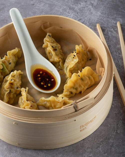 Photo a container of dumplings with a spoon and a spoon