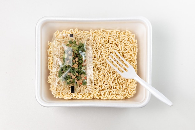 a container of noodles with a plastic fork in it