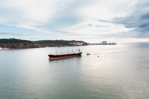 Container ship and small boat in calm sea