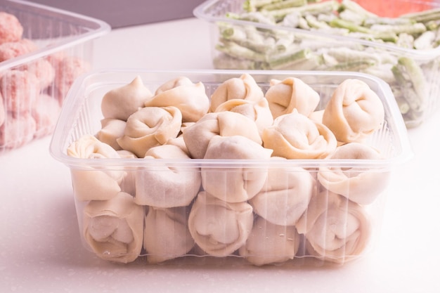 Containers with frozen semifinished meat products from the refrigerator meatballs dumplings chopped beans