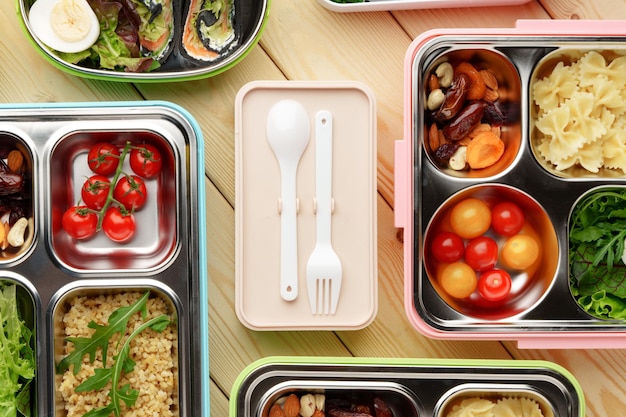 Containers with healthy food on wooden background top view