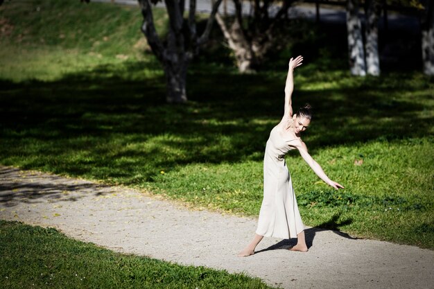 Contemporary ballerina dancing in the park on a sunny day