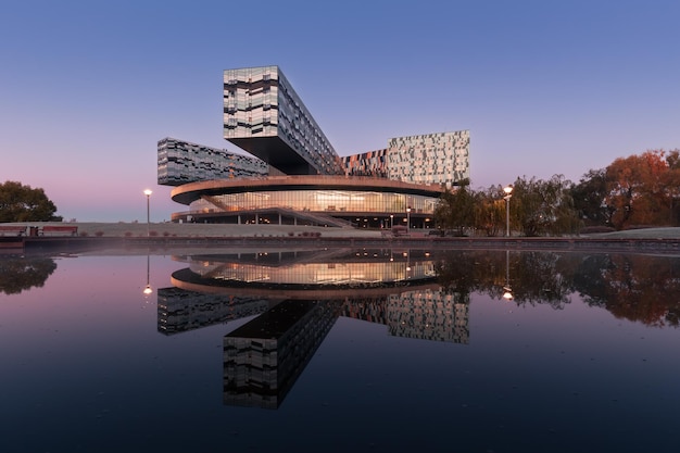 Contemporary building of Skolkovo Management School at sunrise reflected in a pond Moscow Russia