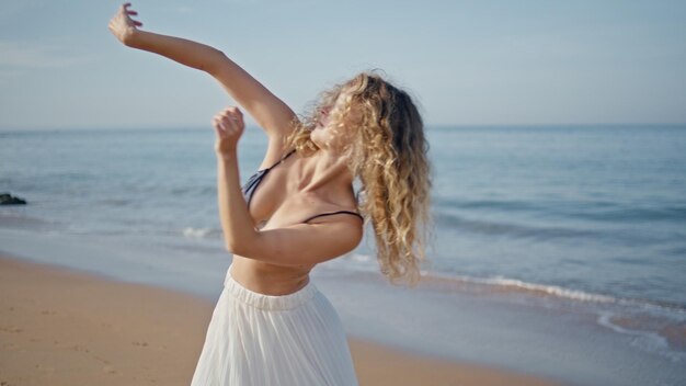 Contemporary performer practicing sensual choreography on sunny beach close up